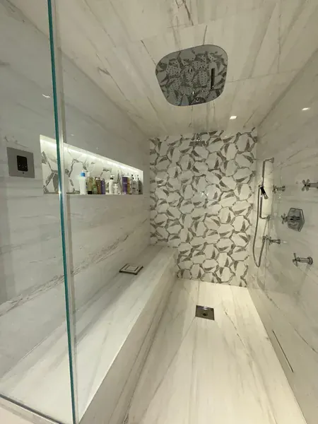 A clean walk-in shower with a glass screen